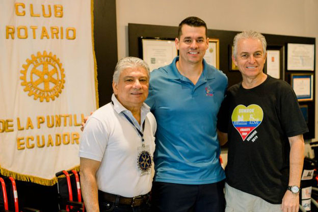 a picture of three people with an Ecuador banner in the background