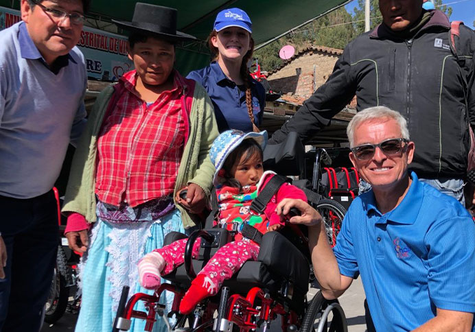 volunteers with the family of a little girl who just got a wheelchair